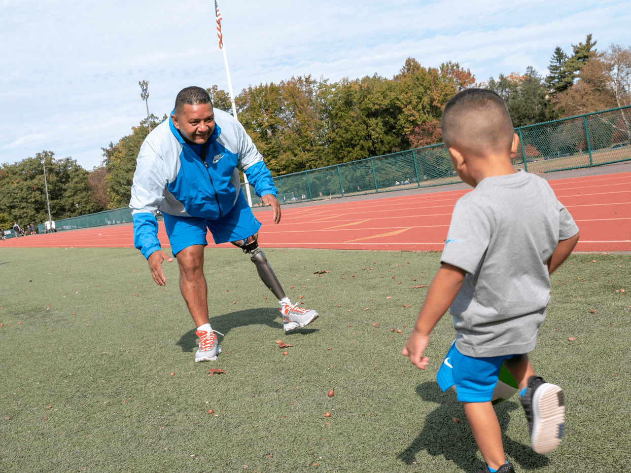 amputee patient playing soccer with his son