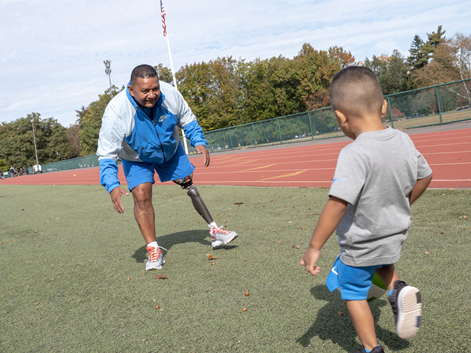 amputee patient playing soccer with his son