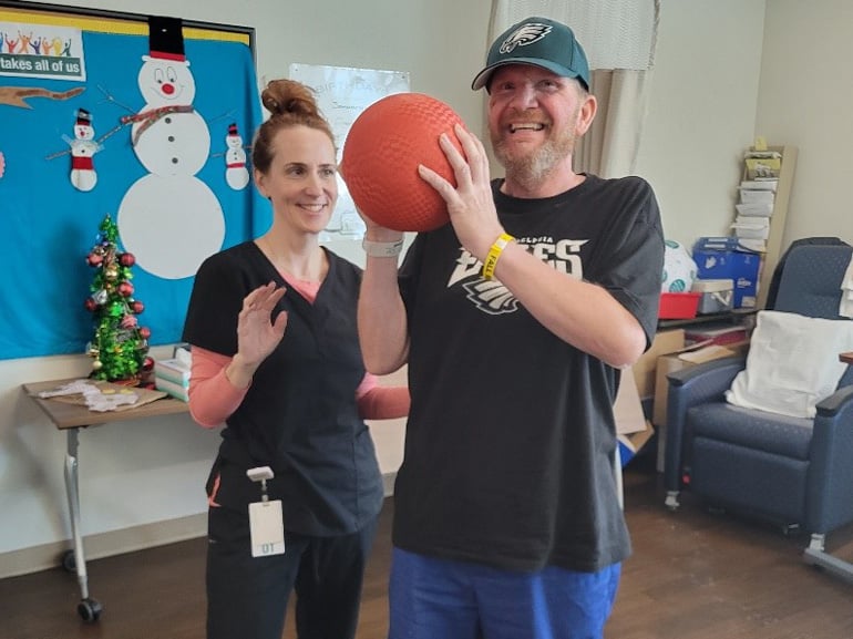 Howard Webb at Kessler Institute for Rehabilitation engaged in therapy with a ball.