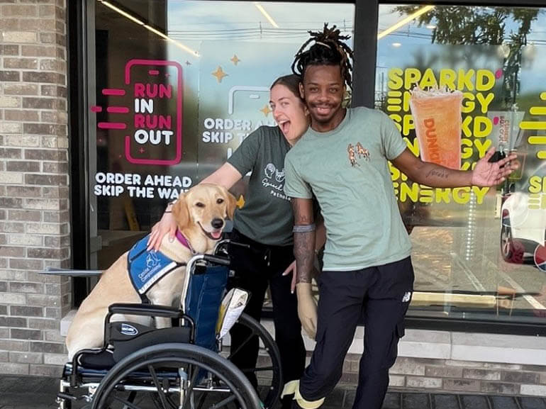 Photo of Joshua Manning with his therapist and therapy dog on a community outing.