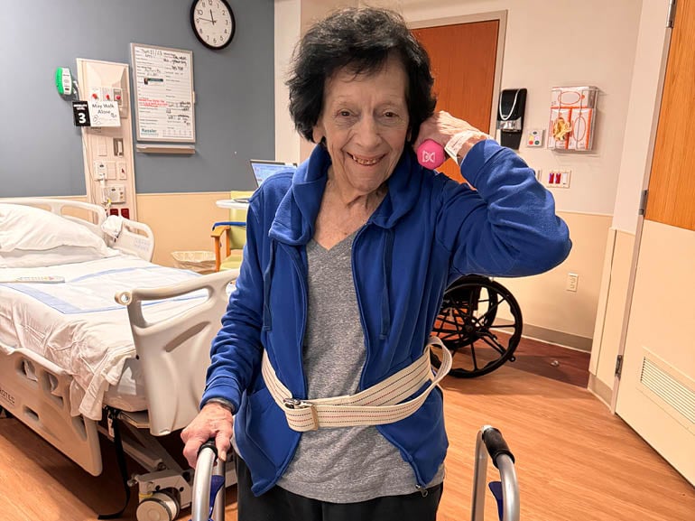 Nicki Delpolito using hand weights in her room at Kessler Institute for Rehabilitation.