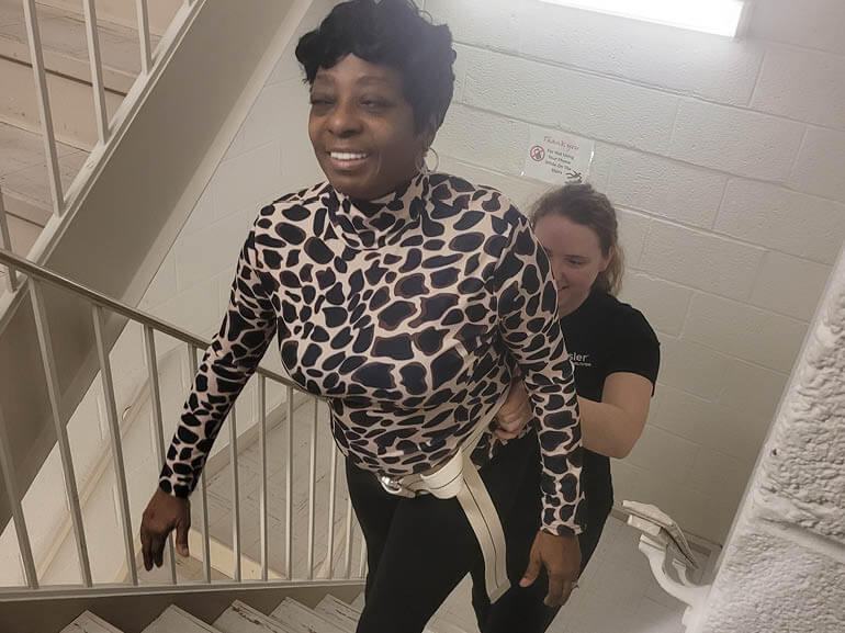 Diana Thomas climbing stairs at Kessler Institute for Rehabilitation.