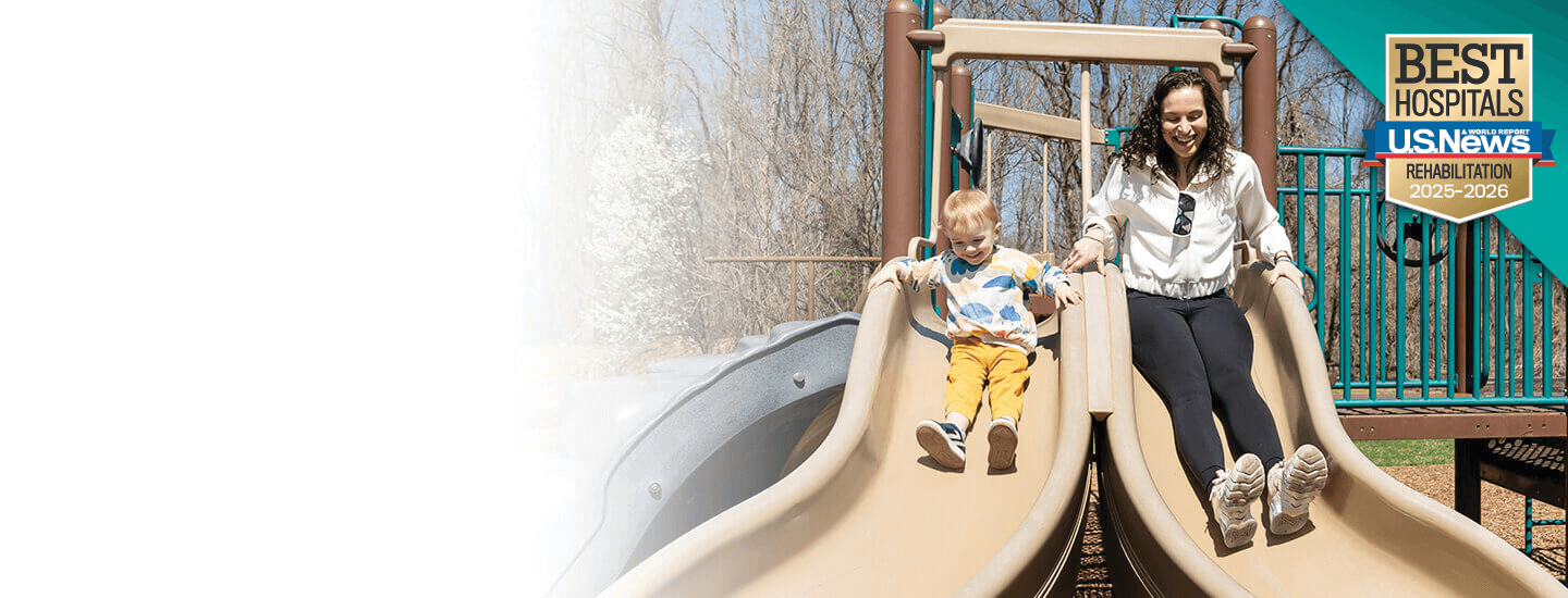 Mother and daughter playing on a sliding board